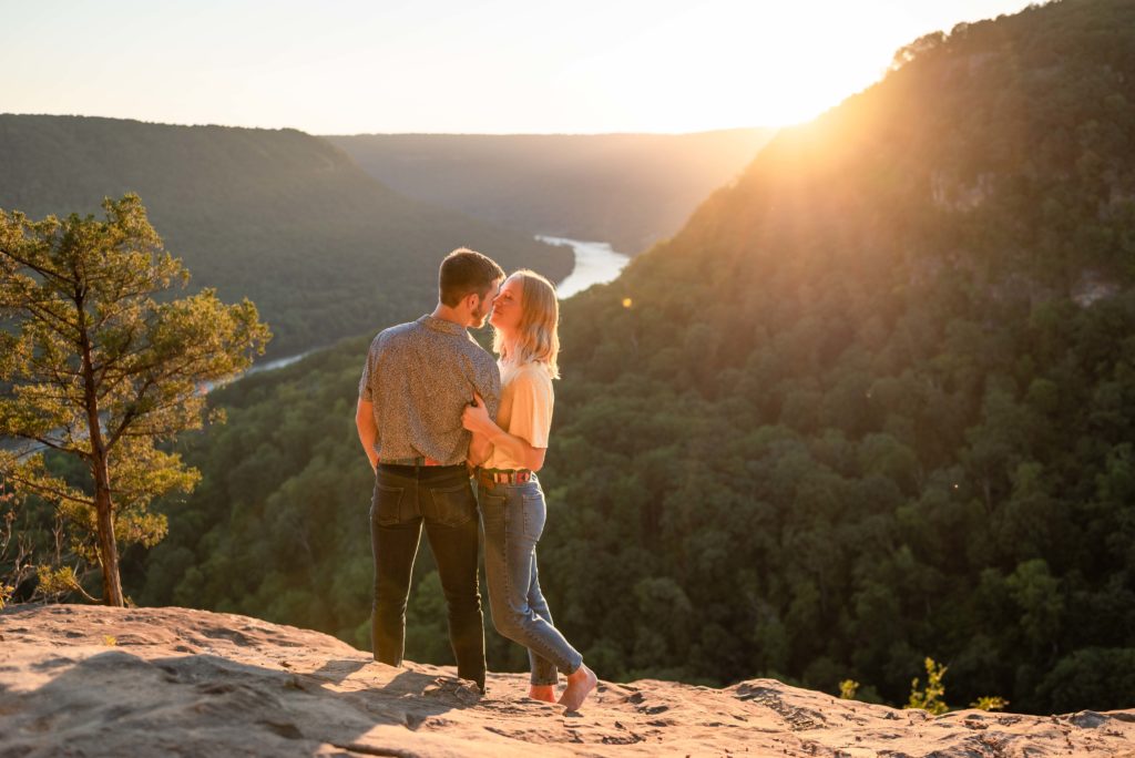 Couple posing for engagement photos at Julia Falls Overlook on Signal Mountain at sunset