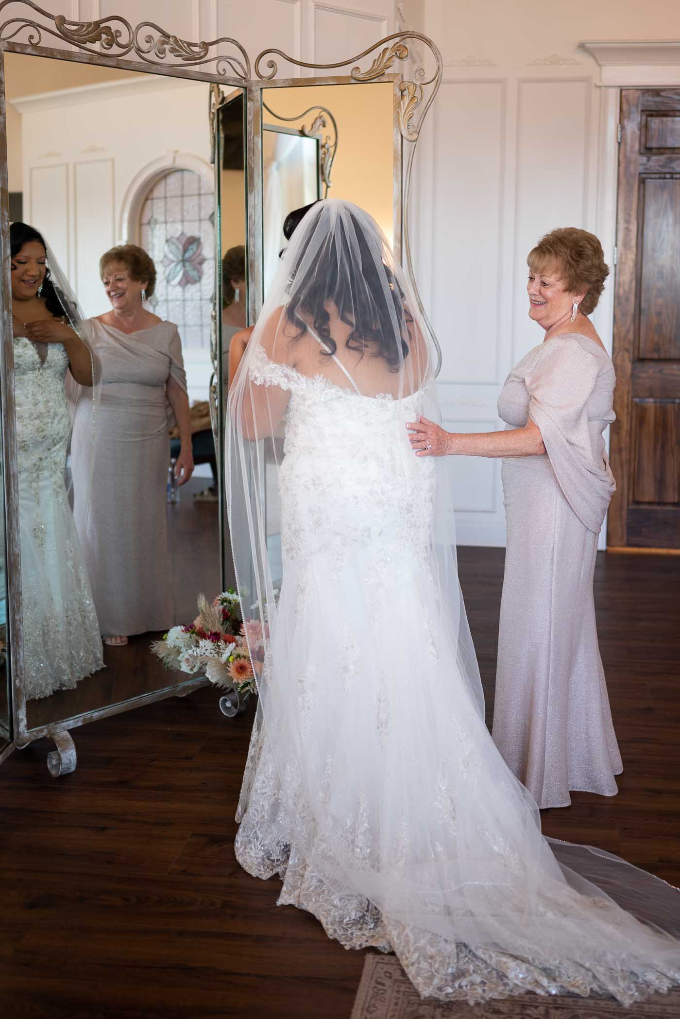Bride and her mom looking in the mirror
