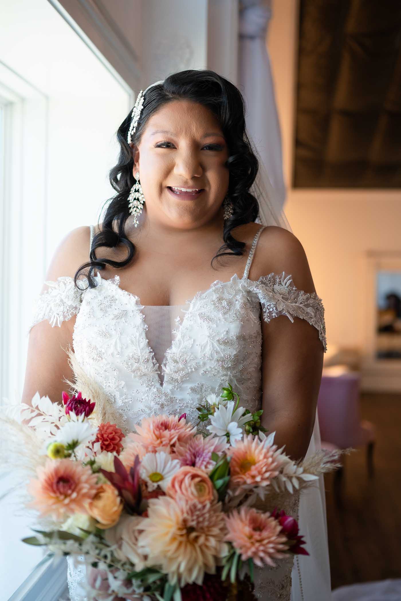 Bride smiling at camera near window