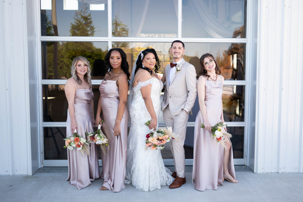 Bridal party standing and smiling at camera