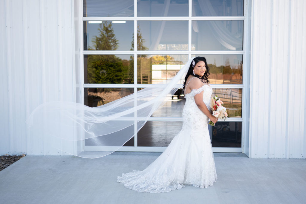 Bride posing with veil flowing in the wind