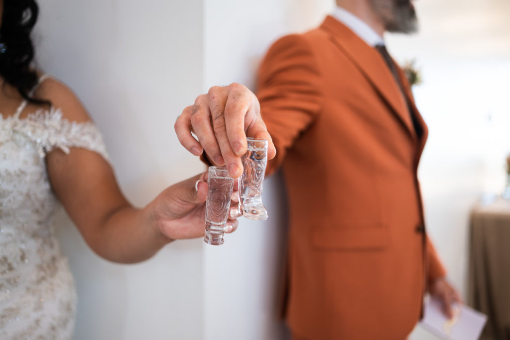 Bride and groom cheersing their shot glasses