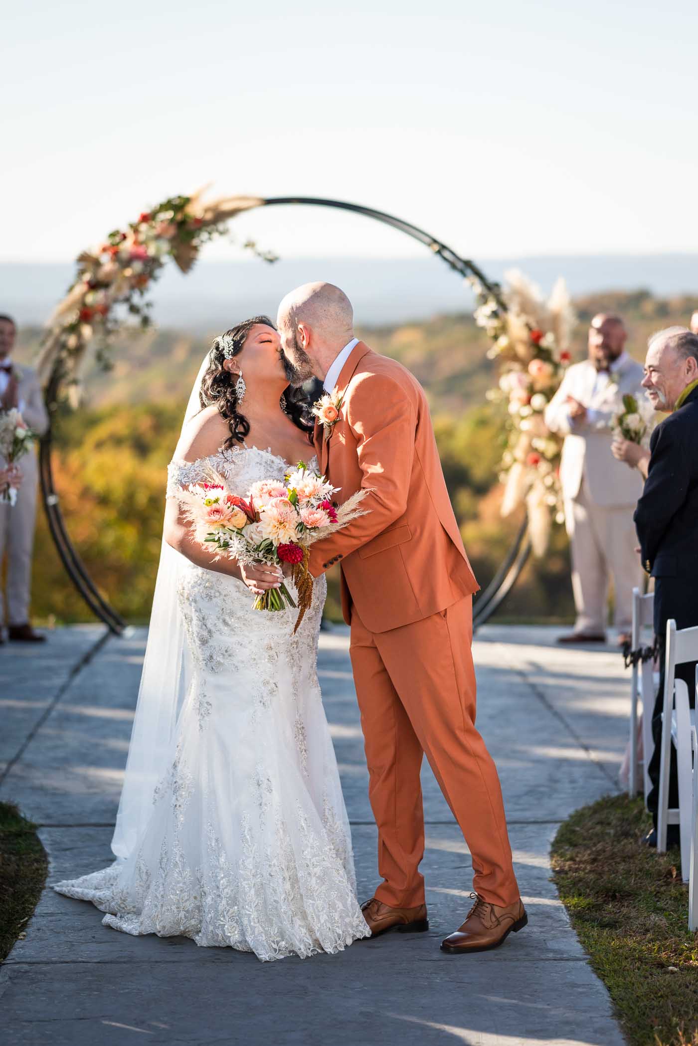 Groom kisses bride as they walk back down the aisle