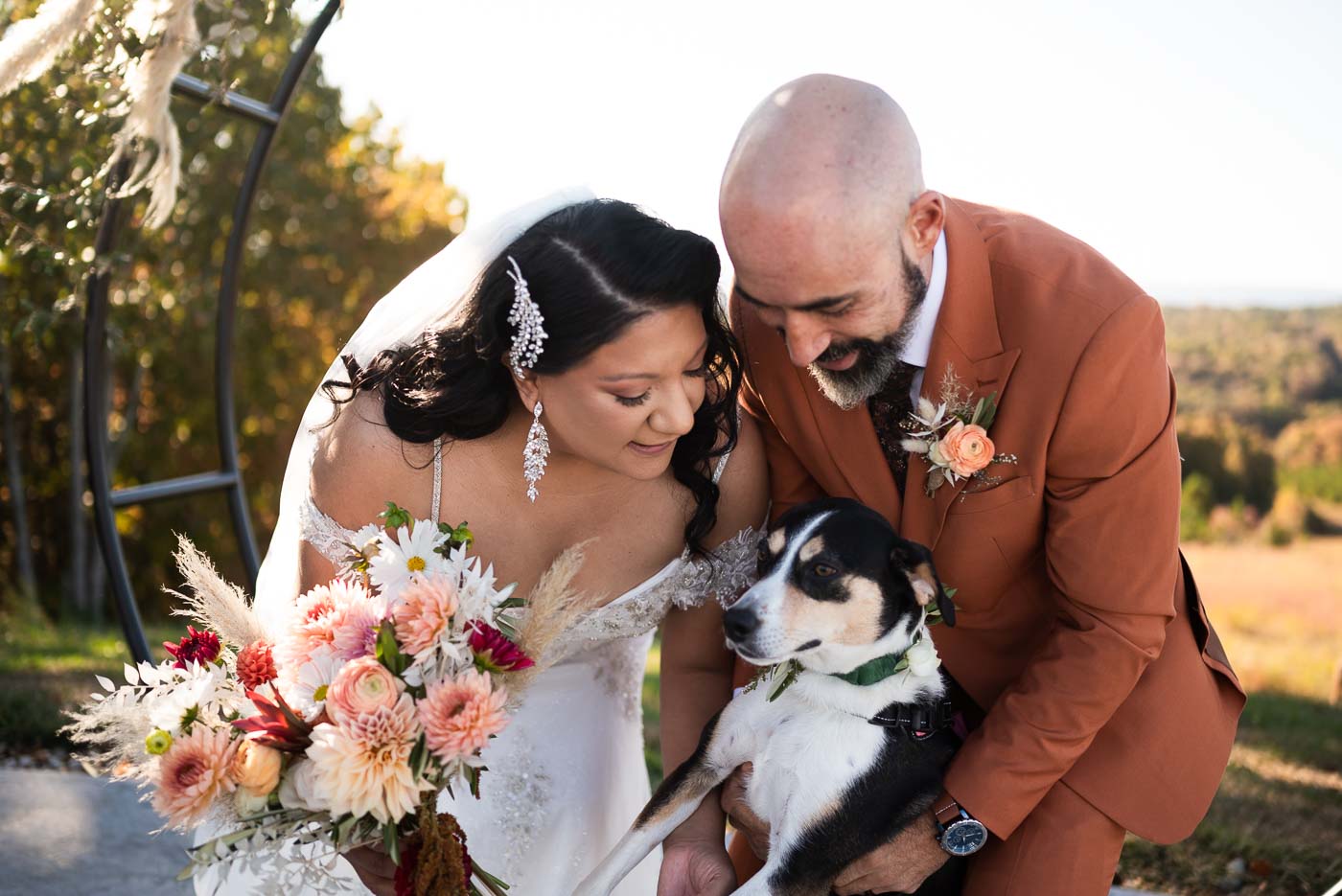 Bride and groom smiling with their dog