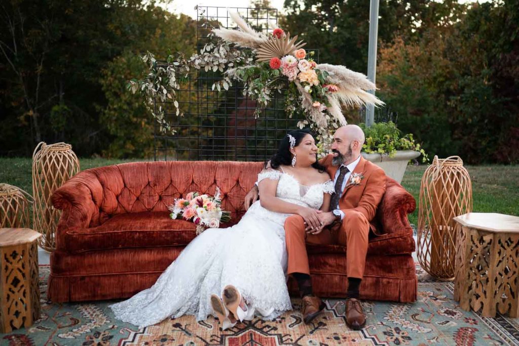 Bride and groom sitting on terracotta couch