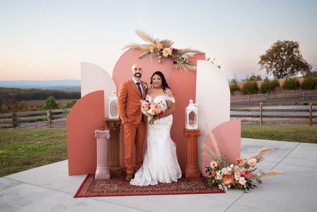 Bride and groom pose in front of photo backdrop